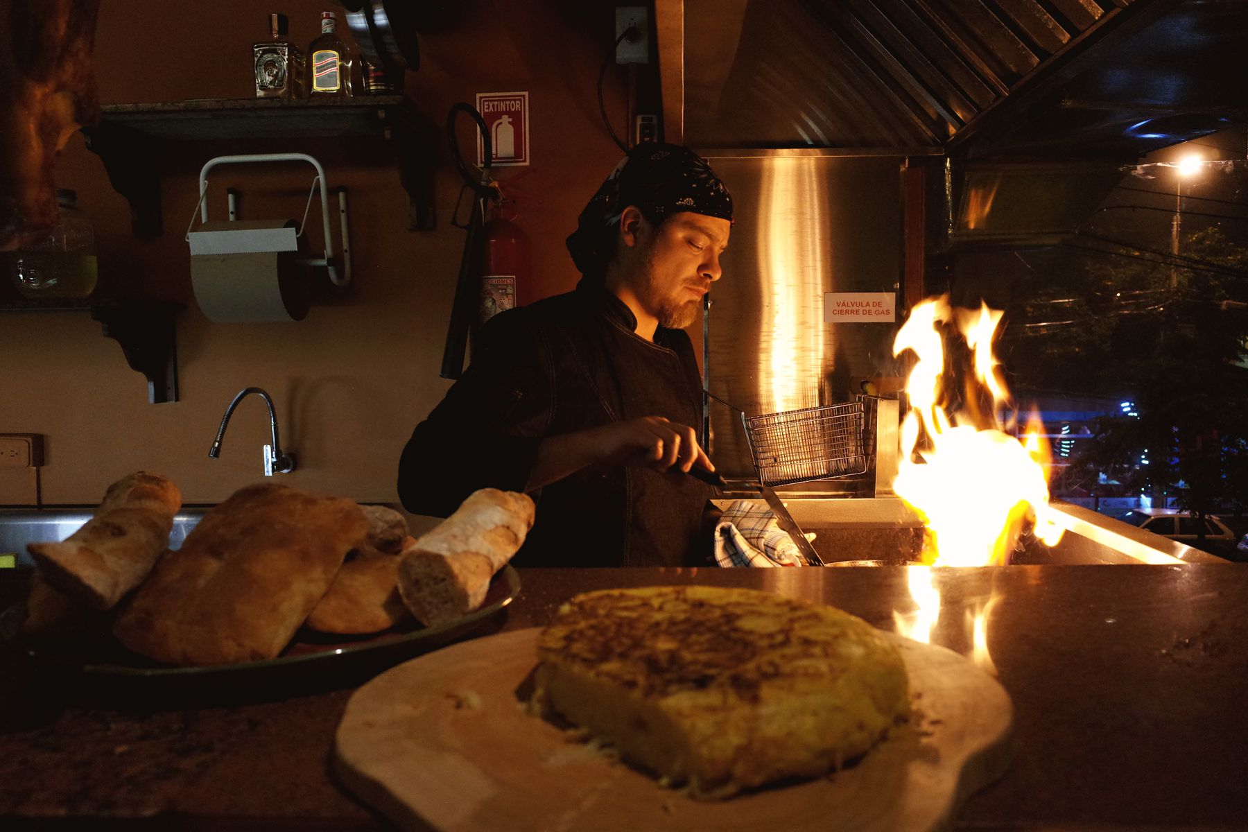 Chef working beside a dramatic open flame